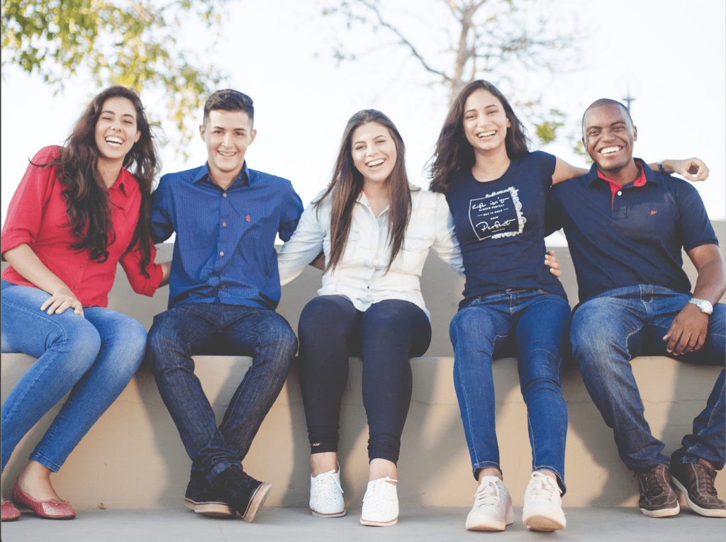 Group of 5 high school students sitting down and smiling